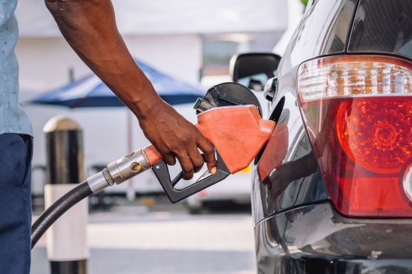 A person refueling a car at a gasoline pump