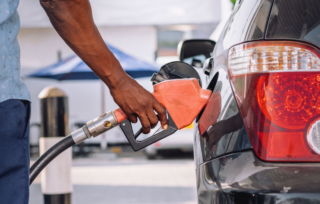 A person refueling a car at a gasoline pump