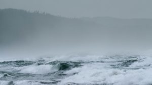 Large waves breaking along a coastline during stormy weather, used as an illustrative image