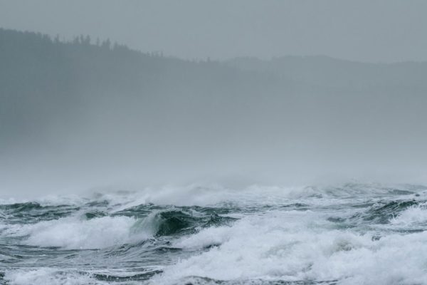 Large waves breaking along a coastline during stormy weather, used as an illustrative image