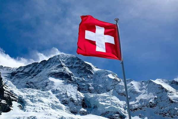 Swiss flag flying in the Alps in front of the Mönch mountain