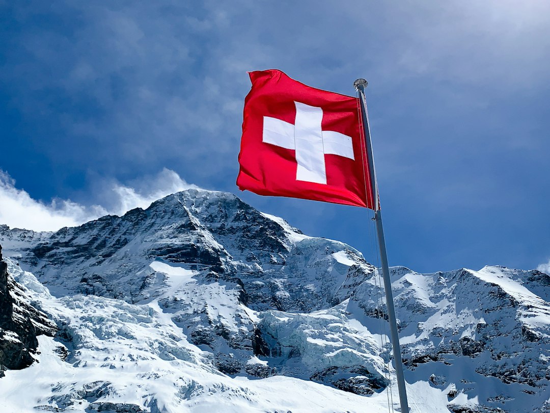 Swiss flag flying in the Alps in front of the Mönch mountain