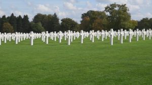 Rows of white headstones at Henri-Chapelle American Cemetery in Belgium, in a frame from the verified U.S. Air Force ceremony video.