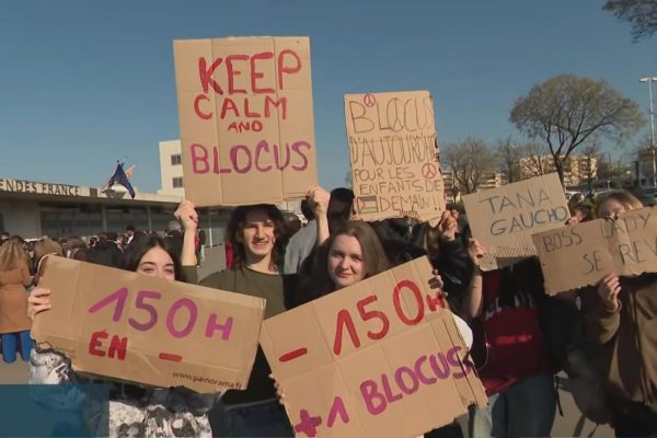 Students hold handmade signs during a high school blockade protest in France