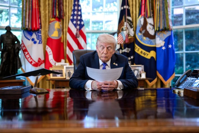 President Donald Trump reviews a document at the Resolute Desk in the Oval Office. Official White House photo.